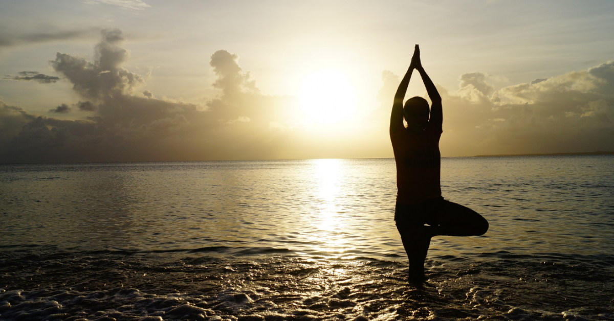 Woman in yoga pose on beach